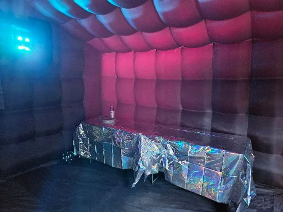 Party table and coloured lighting inside an inflatable tent
