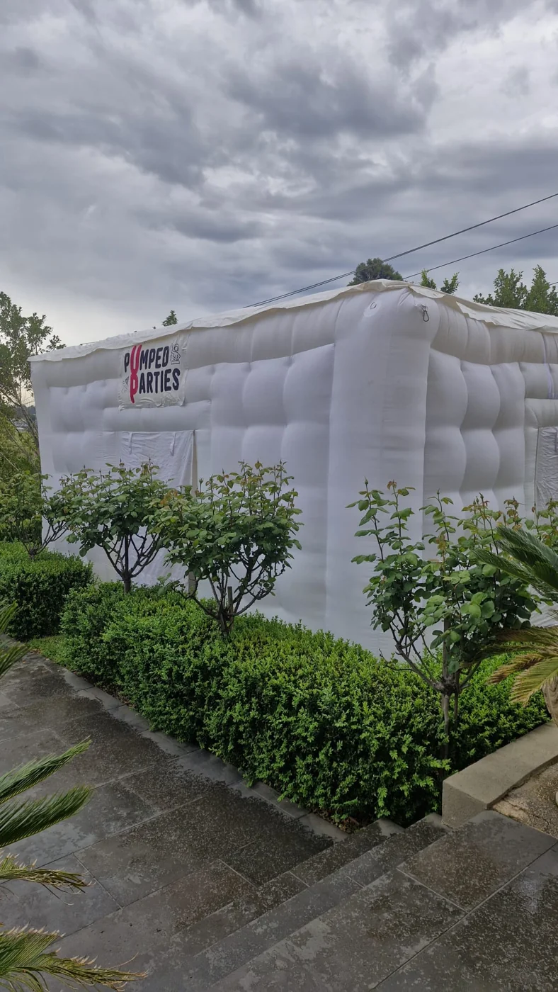 White inflatable party tent set up in a garden